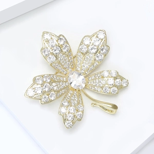 Elegant maple leaf brooch with hollow design and shimmering zircons in golden finish