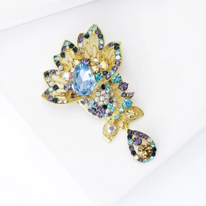Detailed close-up of a vintage-style gold-plated brooch with colorful Czech crystals