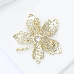 Detailed back view of maple leaf brooch with safety pin clasp and clear zircon settings