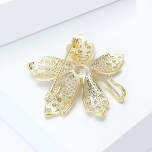 Detail view of the polished gold maple leaf brooch back with secure pin and hook closure