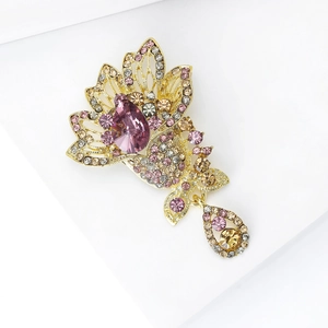 Detail of gold-plated lotus brooch with purple crystals and sparkling Czech rhinestones