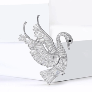 Elegant silver swan brooch with marquise cut crystals on a white display pedestal