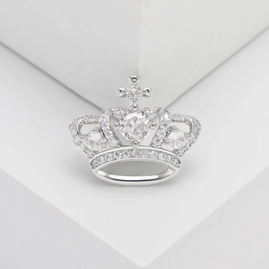 Macro shot of silver crown brooch with micro-pave cubic zirconia and cross detail