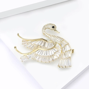 Elegant gold swan brooch with sparkling cubic zirconia stones on white display