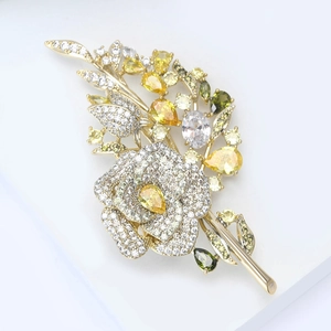 Detailed macro view of zircon flower brooch with yellow pear-cut gemstone on white stand