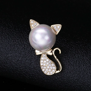 Macro detail of cat brooch with a large white pearl and zircon pave on dark leather