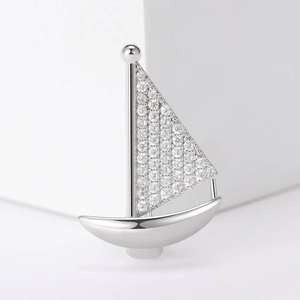 Exquise broche voilier en argent avec zircons micro-pavés sur une plateforme blanche