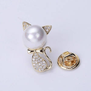 Detailed macro of a cat-shaped golden brooch with large pearl head and zircon crystal stones