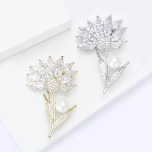 Elegante Blumenbroschen mit Zirkonia-Blütenblättern und Perlen auf weißen Stufen