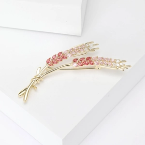 Detailed close-up of wheat brooch with pink gradient marquise stones on white base