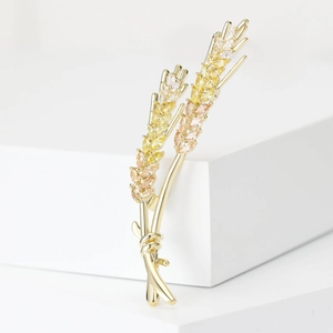 Macro detail of elegant golden wheat brooch featuring sparkling champagne zircon stones