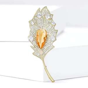 Elegant gold-tone leaf brooch with sparkling zircons and a large orange pear-shaped stone