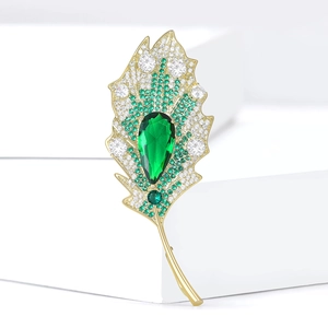 Elegant gold leaf brooch with emerald green pear-cut stone and micro-set cubic zirconia