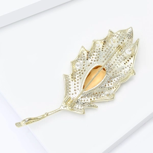 Detailed back view of leaf brooch with amber gemstone and secure safety pin clasp