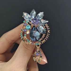 Detail of elegant water drop flower brooch with blue crystals and gold-tone finish