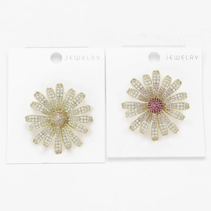 Close-up of golden sunflower brooches with champagne and magenta zircon pave setting