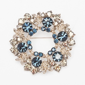 Macro shot of vintage silver wreath brooch with blue gemstones and floral pattern