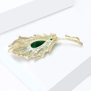 Detailed back view of a leaf brooch showing intricate metal cutout and safety pin clasp