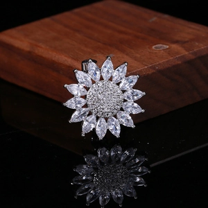 Vista macro de broche de girasol de plata con pétalos de circonita y centro de pavé fino