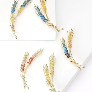 Elegant wheat stalk brooches with colorful zircon stones in gold plating set on white background