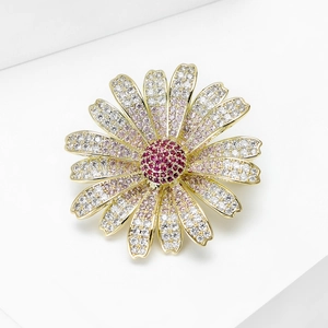 Macro shot of sparkling daisy brooch with pink gradient crystals and gold base details