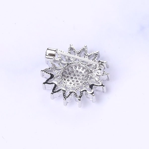 Detalle macro del cierre de seguridad trasero de un broche de girasol plateado con circonio