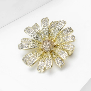 Macro detail of the daisy brooch featuring gold plating and shimmering pavé zircon petals