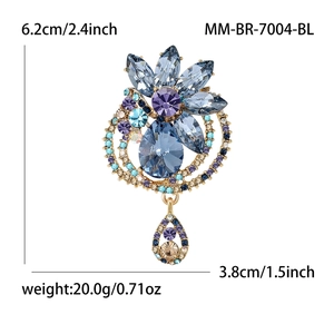 Elegant gold-tone flower brooch with blue and purple crystals and teardrop pendant