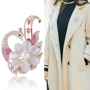 Elegante spilla a fenice e pavone con petali di opale e perle su cappotto beige