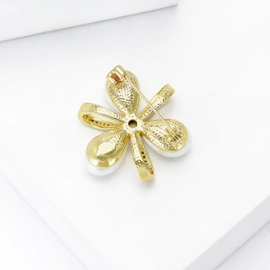 Broche fleur dorée vue arrière montrant le fermoir rotatif sécurisé et le fini métallique