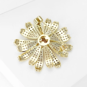 Macro view of the golden flower brooch back showing hollowed petals and pin clasp