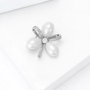 Détail de la broche nœud en perles avec cristaux brillants et finition argentée