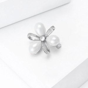 Vue macro d'une broche florale en perles avec base en argent et centre en zircone