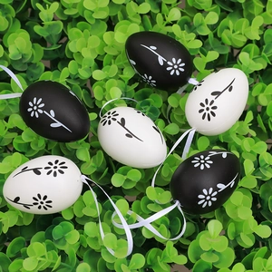 Set of 6 black and white Easter egg ornaments with floral patterns on green foliage