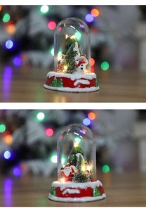 Detailed view of glowing glass dome ornaments featuring Santa and snowman with LED lights