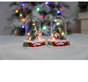 Close-up of Santa and Snowman glass globe with warm LED lights and red base