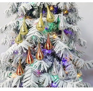 Weihnachtsbaum-Tropfenanhänger in Gold und Silber auf weißem, verschneitem Baum