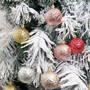 Bolas de Navidad de 6 cm con relieves sobre un fondo de árbol de Navidad nevado