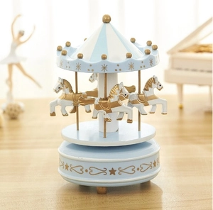 Dettaglio carillon a giostra blu cielo con accenti dorati e cavalli bianchi decorati