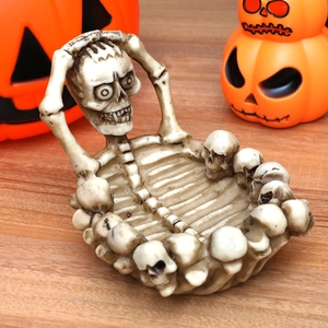 Skull shaped resin storage bowl for Halloween decor on rustic wooden tabletop background