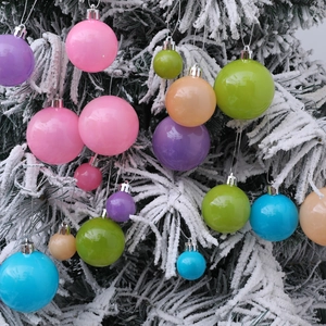 Lot de boules de Noël colorées et brillantes suspendues sur des branches de sapin enneigées