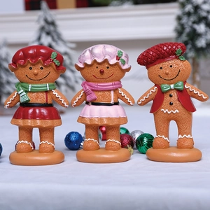 Three festive Christmas gingerbread figurines with detailed sugar frosting and snowy backdrop