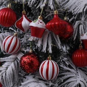 Set of 12 red and white Christmas ball ornaments on a snowy tree for festive holiday decor