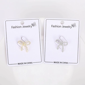 Macro view of bow knot earrings with white zircon paving in gold and silver finishes