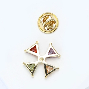 Close-up of gold-plated star brooch with four-color triangle gemstones and butterfly clasp