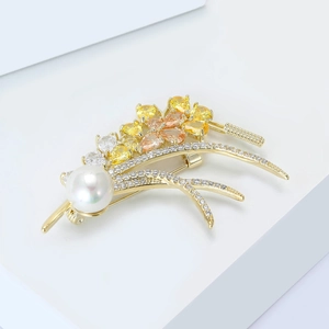 Close-up of golden wheat ear brooch with large white pearl and yellow zircon petals