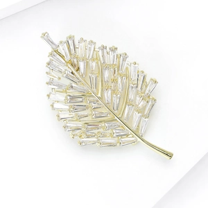 Macro view of golden leaf brooch featuring sparkling cubic zirconia stones and fine lines