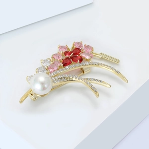 Macro shot of an elegant wheat ear brooch with white pearl and red zircon crystals
