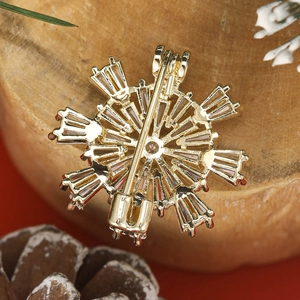 Fashionable snowflake brooch with zircons in gold plating shown from the back view