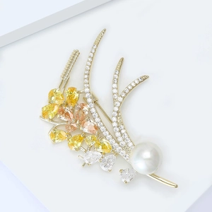 Detailed view of wheat brooch with colored pear-cut stones and a large round pearl accent